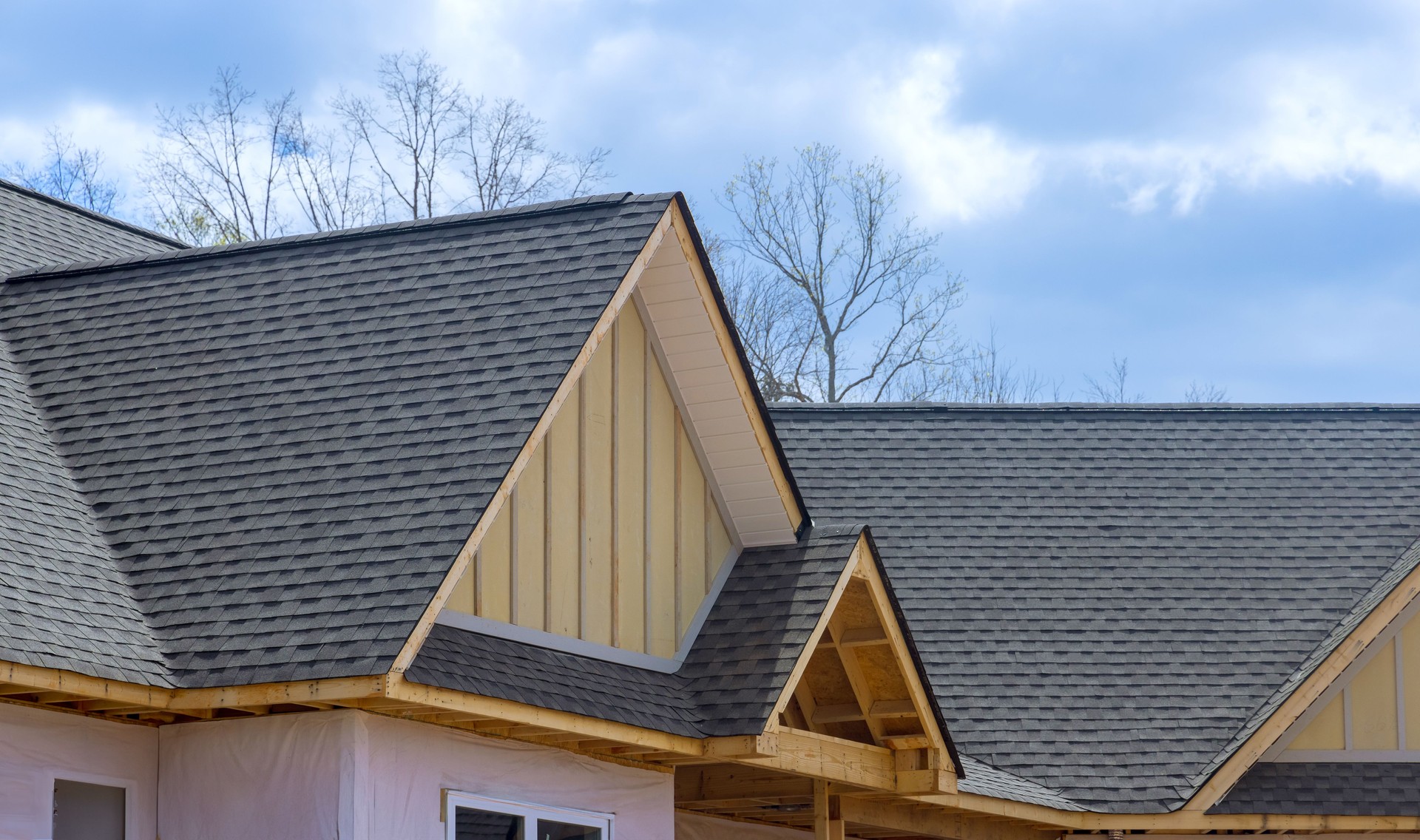 On newly constructed home, overlapping asphalt shingles are seen on a roof